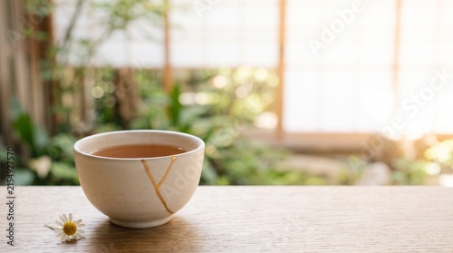 Tea cup on wooden table with flower in serene garden setting  