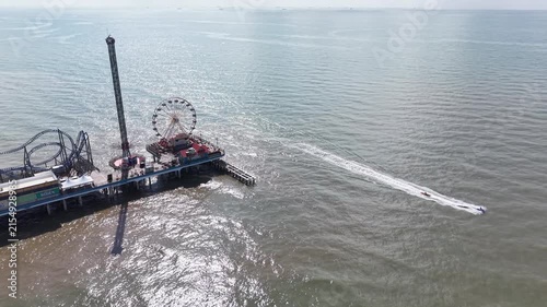 Aerial view of Galveston Island coastal town in Texas and Historic Pleasure Pier amusement park on ocean shoreline on a Sunny Day