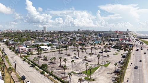Aerial view of Galveston Island coastal town in Texas and Historic Pleasure Pier amusement park on ocean shoreline on a Sunny Day