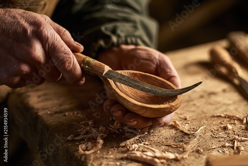 Craftsmanship in Wood Carving: A Masters Hands Shaping a Wooden Bowl