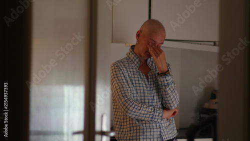 Female cancer patient standing alone in kitchen during recovery journey, highlighting emotional strain, resilience, uncertainty, reflection and personal strength