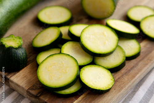 Foto Raw Green Organic Zucchini on a Wooden Board, side view