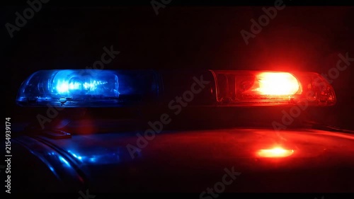 Close-up of an illuminated emergency vehicle light bar flashing red and blue at night
