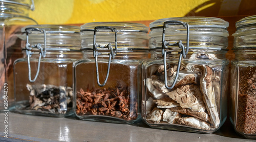 Storage jars featuring wire bail closures for dried goods and spices. Clear glass containers with rubber gasket seals for herbs and mushrooms.