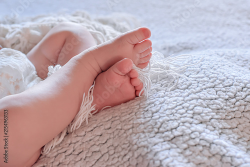 фотографія Close-up of tiny newborn baby feet resting on a soft white knitted blanket