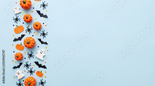 Flat lay composition with small orange pumpkins and black bats on a light blue background for halloween celebration