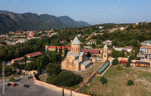 Aerial view of an ancient church and monastery complex in a scenic mountainous landscape