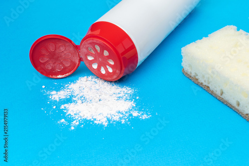 Foto Cleaning Sponge and Talcum Powder on Blue Background for Household Chores Concep