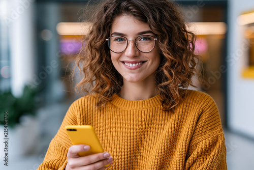 Remarkable and eye-catching visual of young adult using a smartphone app to activate an online promo code, bright contemporary environment, realistic e-commerce concept, premium stock image