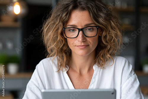 Amazing close-up or wide angle showing young professional comparing online offers and promo codes on a tablet, stylish home office environment, clean modern aesthetic, commercial stock photography