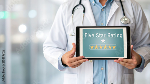 Healthcare professional holding five-star customer satisfaction rating tablet in clinic setting