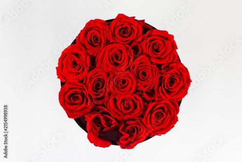 Bild auf Leinwand Top-down overhead view of vibrant red preserved roses arranged in a round hat b