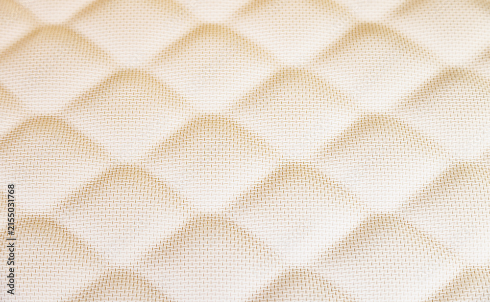 Fototapeta premium Quilted cream fabric creating diamond pattern texture