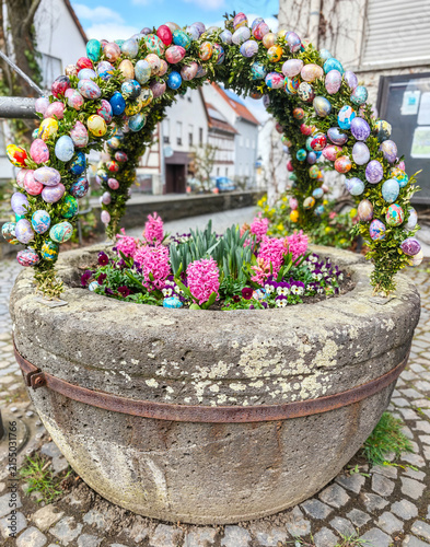 Osterbrunnen decorating stone well with colorful easter eggs