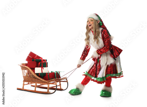 Принти на полотні Woman wearing elf costume with sledge full of Christmas gifts on white backgroun