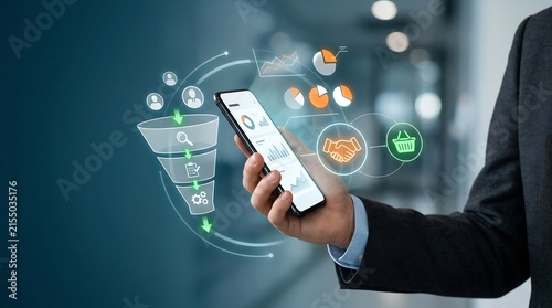 Hand holding smartphone with sales funnel interface in office