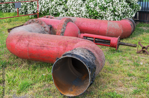 Piece of old rusty metal pipe, half meter in diameter, with shut-off valve