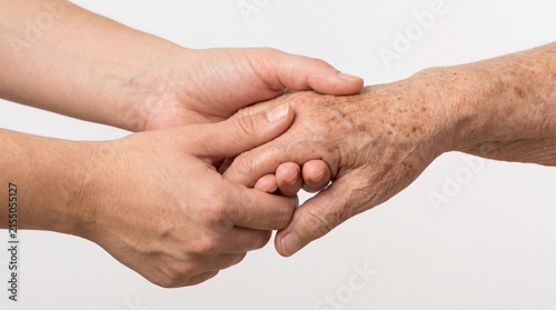 A close-up shot of two hands, one younger and one older, gently holding each other, symbolizing care and connection