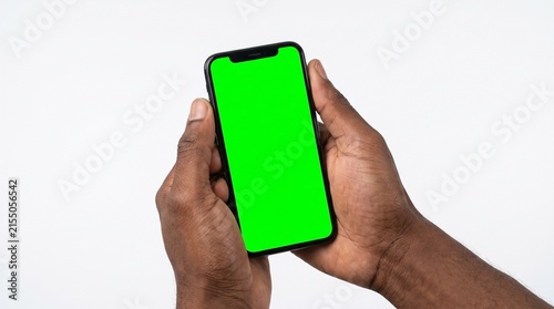 Holding a smartphone with a green screen in hand