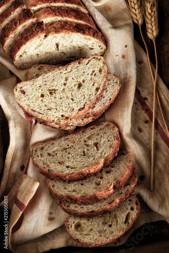 Artisan Bread Still Life. A fresh baked and sliced loaf of multi grain bread on a kitchen towel.