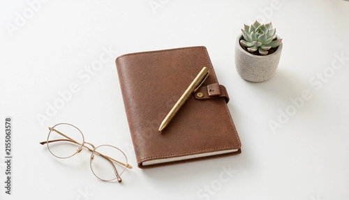 Leather notebook with pen on minimalist desk