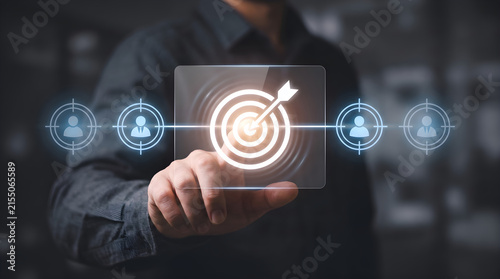 Professional businessman touching a glowing digital interface showing target marketing strategy to reach specific customer audience segments