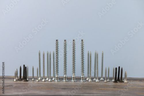 Konstfotografi Variety of screws arranged in a beautiful pattern on a wooden surface showcasing