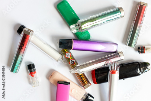 Canvas Print Scattered colorful disposable vapes and pods with toxic warning symbols, representing nicotine addiction, chemical health risks, and dangerous vaping habits on a white background