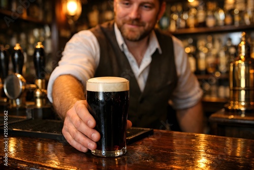 Bartender Serving Pint of Dark Beer in Traditional Irish Pub