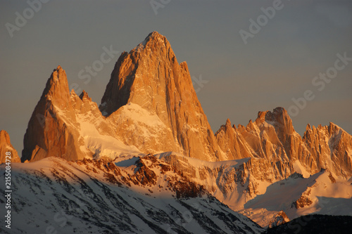 Famous Mount Fitz Roy glowing at sunset above snowy peaks in El Chaltén, Patagonia, Argentina.