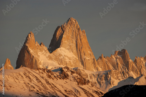 Famous Mount Fitz Roy glowing at sunset above snowy peaks in El Chaltén, Patagonia, Argentina.