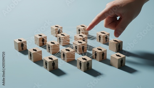 Hand selecting a person from a connected network of wooden cubes with human icons.