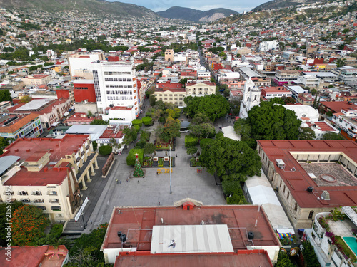 Drone view of Chilpancingo, Mexico. Main civic square with a Christmas tree, diverse buildings, and urban sprawl on distant hills