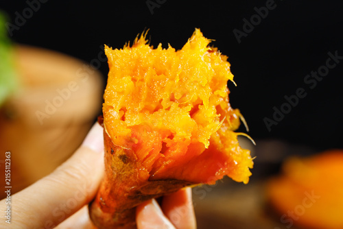 Hand Holding Fresh Baked Sweet Potato with Fluffy Orange Flesh - Healthy Food Concept