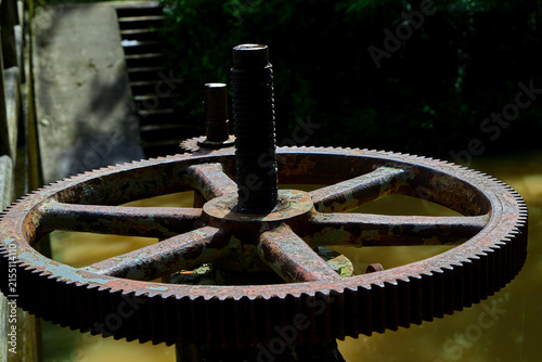 Old rusty handwheel mechanism over water