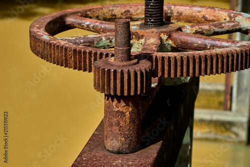 Old rusty handwheel mechanism over water