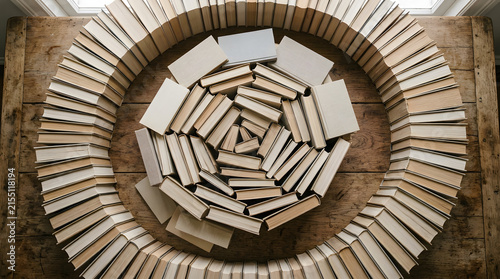 Books arranged in spiral pattern on wooden table top view