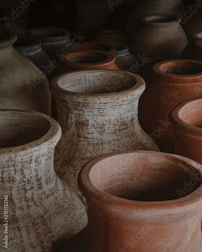 Collection of earthenware pottery vessels in rustic setting