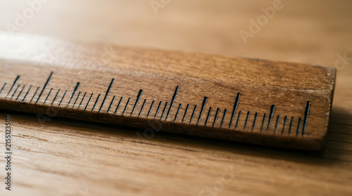 Wooden ruler with engraved measurement markings on wood surface
