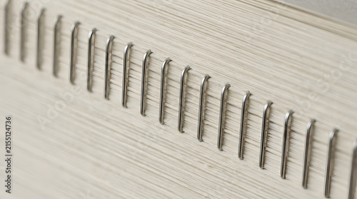 Close-up of metal staples binding pages in a stack of paper
