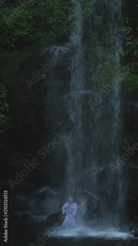August 9 2026, Kanagawa Prefecture, Japan; man performing meditation under Yuhi no Taki waterfall in Kanagawa Prefecture.