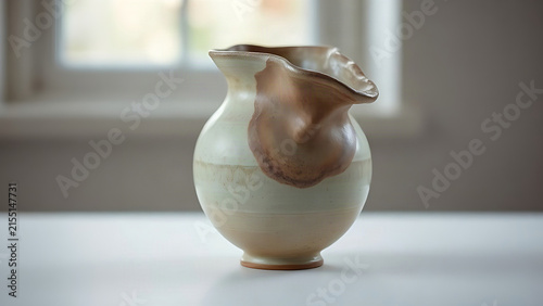 A failed ceramic vase with a warped rim and an irregular bulge on its body.