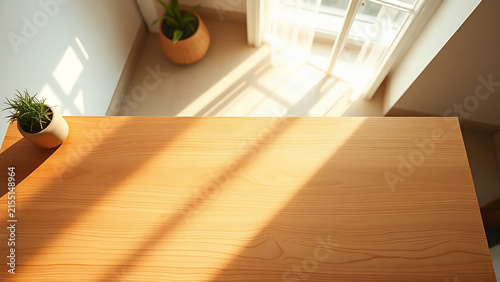 Minimalist wooden desk illuminated by morning sunlight, showcasing simplicity.