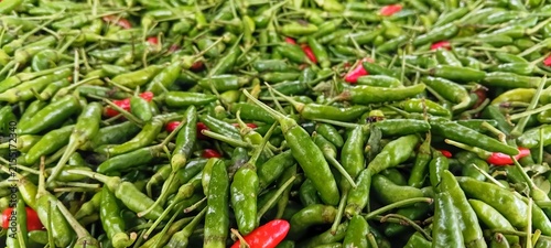 Fotografie Freshly harvested organic fiery raw bird eye chilies stacked for sale at local v