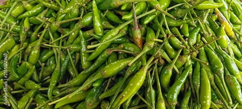 Quadro su tela Macro close up shot of vibrant fresh small hot bird eye chilies in traditional m