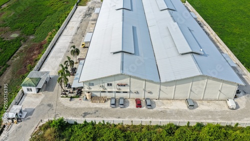Принти на полотні A warehouse with a gray roof stands next to open fields in daylight