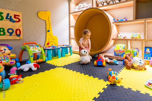 фотографія Toddler exploring colorful indoor playroom with plush toys, games, and education