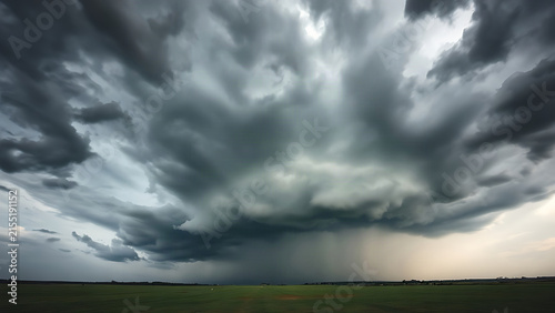 Heavy low-hanging dark storm clouds before a thunderstorm, view from the ground.
