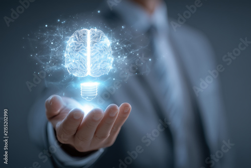 Businessman holding glowing digital brain lightbulb