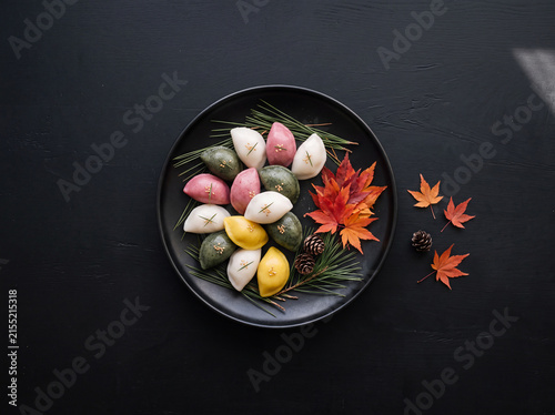 검은색 도자기 접시에 솔잎과 붉은 단풍잎으로 장식한 정갈한 오색 송편 탑뷰